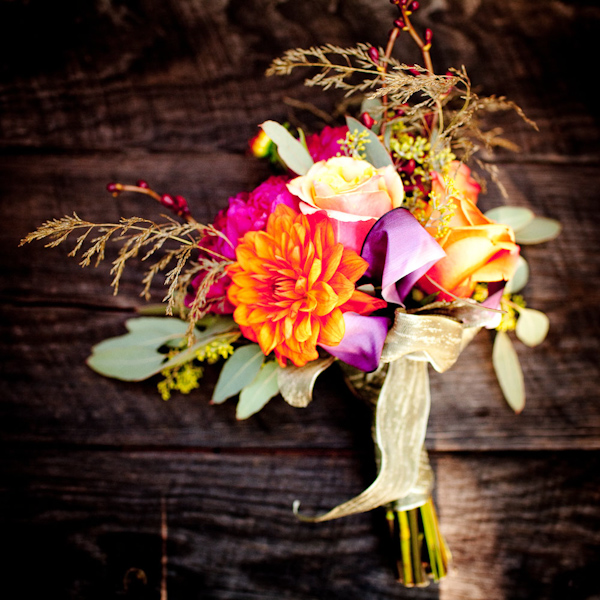 a gorgeous dark pink, orange, yellow, ivory, brown, purple, and green floral bouquet - photo by New Mexico based wedding photographers Twin Lens